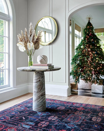 Decorative interior with a marble table, Christmas tree, hand knotted oushak rug, and decorative mirror.